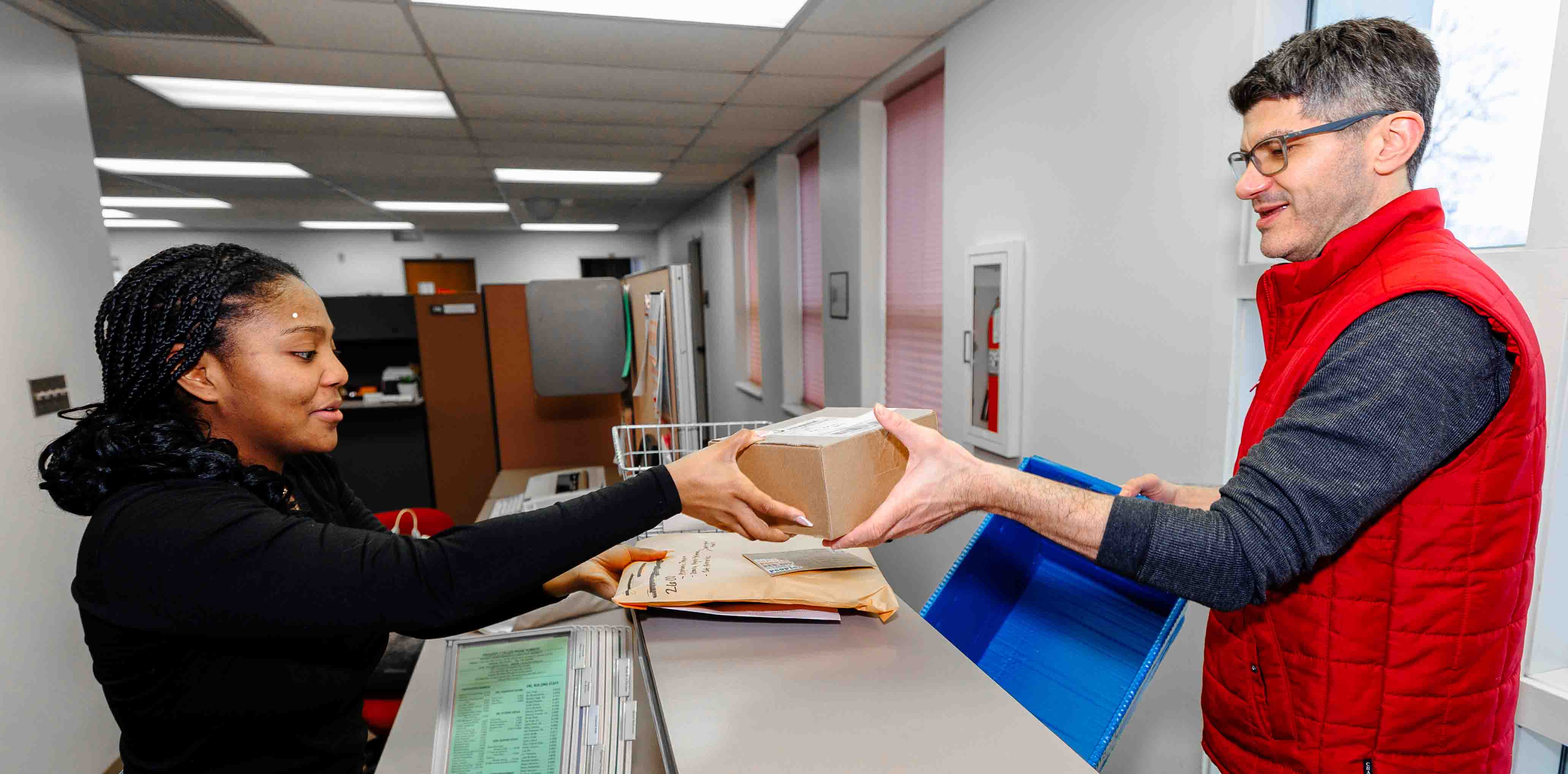 A mail service employee delivering to a customer.