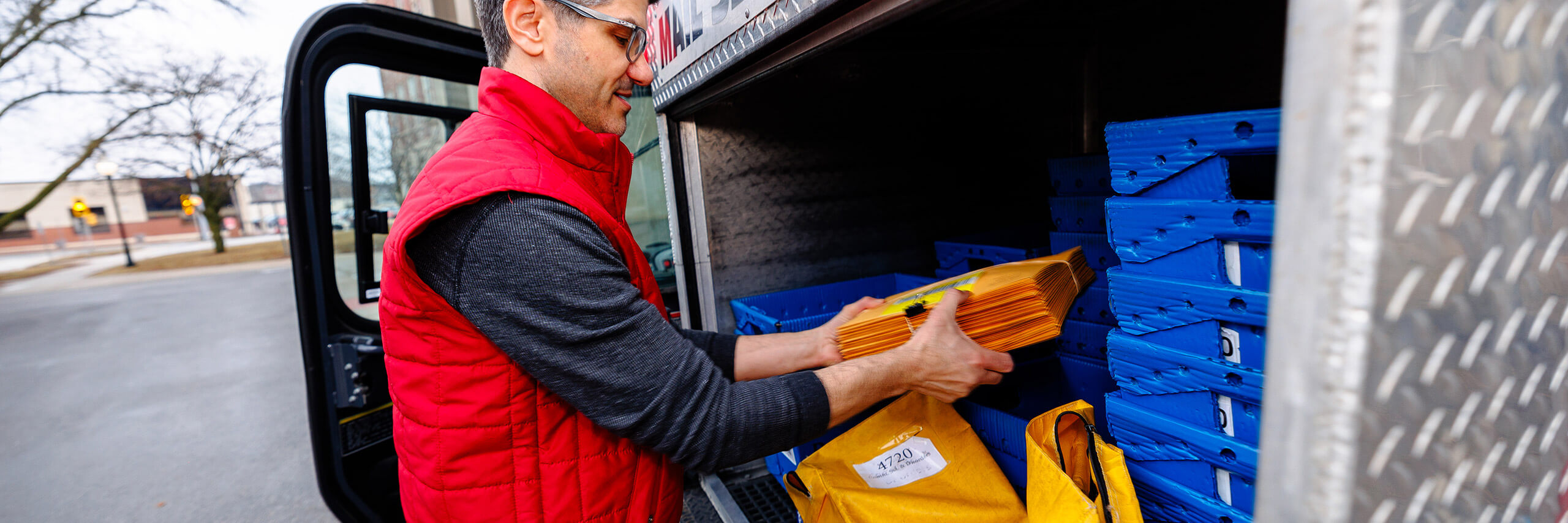 A mail service employee is preparing mail for delivery.